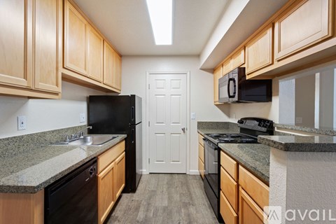 A kitchen with wooden cabinets and black appliances.