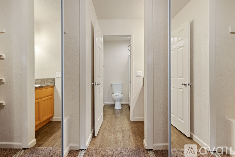 A hallway with a toilet at the end.