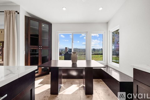 A modern kitchen with a table and a view of the outside.