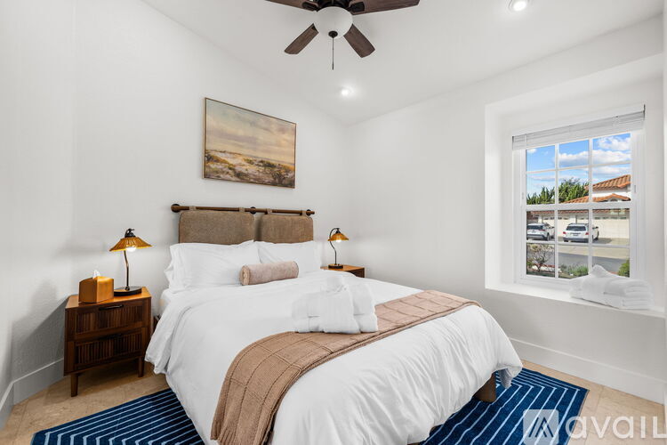 A bedroom with a large bed and a ceiling fan.