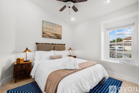 A bedroom with a large bed and a ceiling fan.