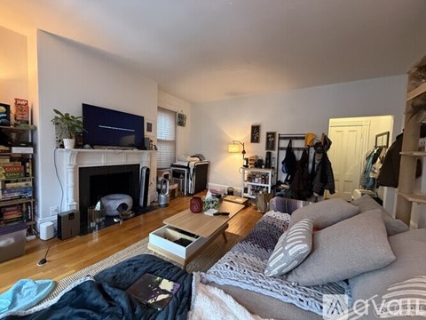 A living room with a fireplace and a television on the wall.