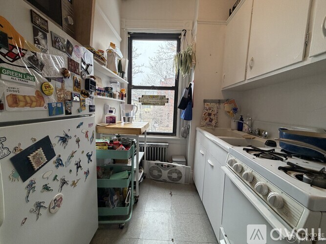 A kitchen with white appliances and a white refrigerator covered in magnets.