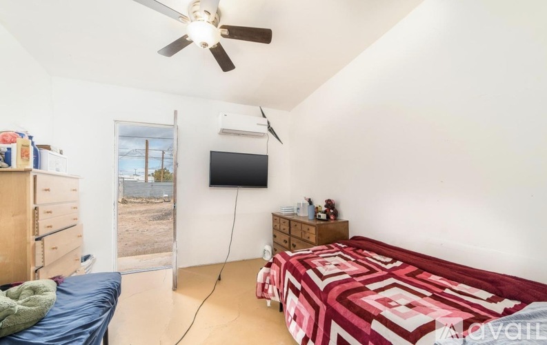 A bedroom with a bed, dresser, and a ceiling fan.