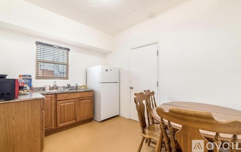 A kitchen with wooden cabinets and a white refrigerator.
