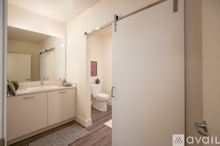 A bathroom with a toilet, sink, and mirror.