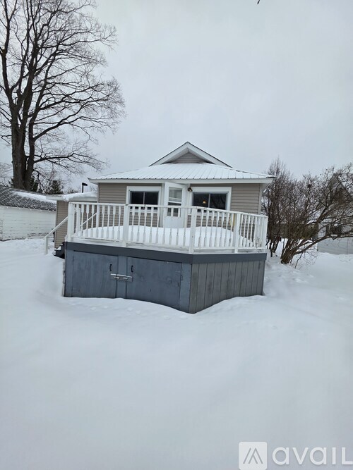 A house with a white fence is surrounded by snow.
