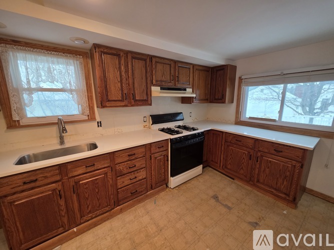 A kitchen with wooden cabinets and a stove top oven.