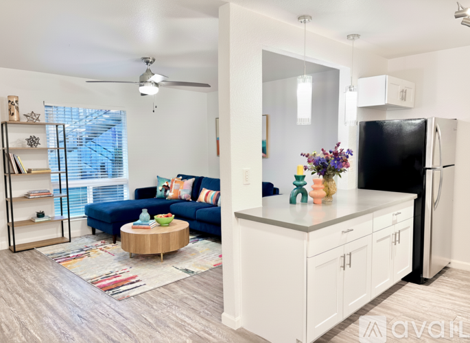 A kitchen with a black fridge and white cabinets.
