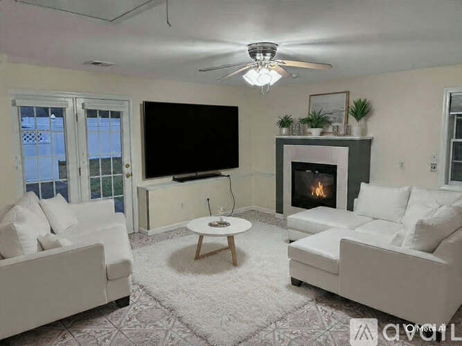 A living room with a fireplace and a flat screen TV.
