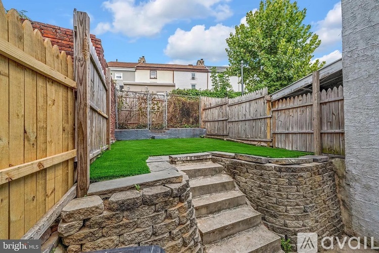 A backyard with a stone staircase leading to a grassy area.