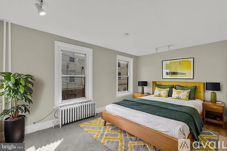 A bedroom with a bed, nightstand, and window.