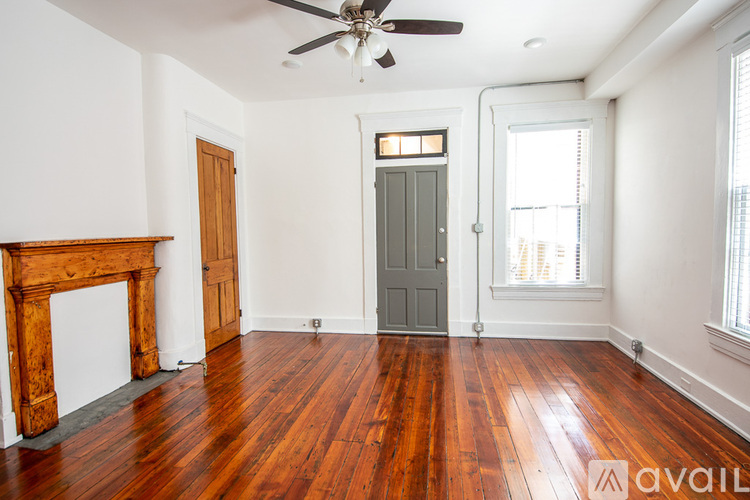 A room with a wooden floor and a fireplace.