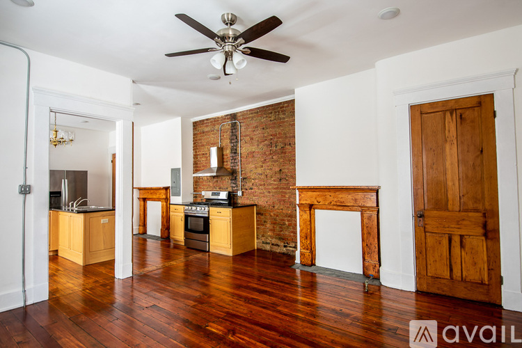 A room with a brick wall and wooden floors.