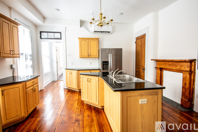 A kitchen with wooden cabinets and a black countertop.