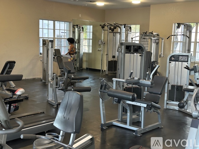 A gym with a variety of equipment including treadmills, weights, and exercise machines.