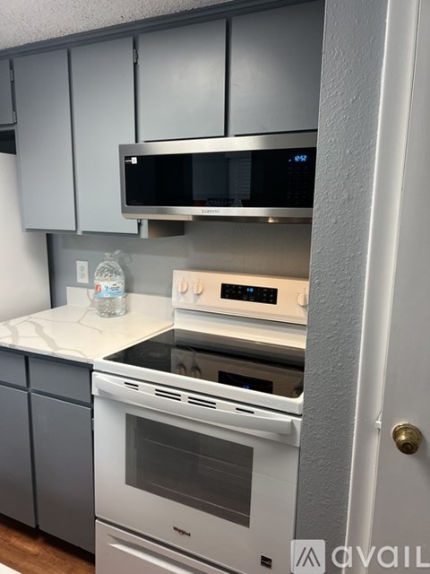 A kitchen with a white oven and a microwave above it.
