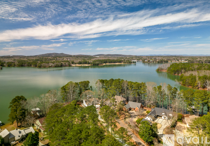 A bird's eye view of a residential area with a lake in the foreground.