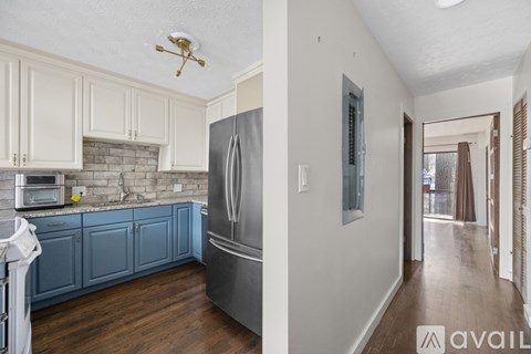 A kitchen with blue cabinets and a stainless steel refrigerator.