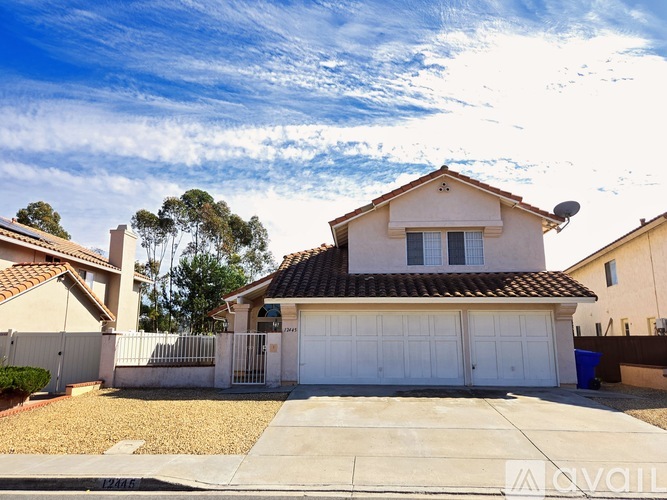 A house with a white garage door and a brown roof.