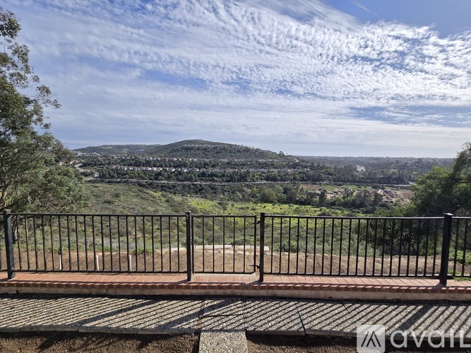 A view from a balcony overlooking a green valley.
