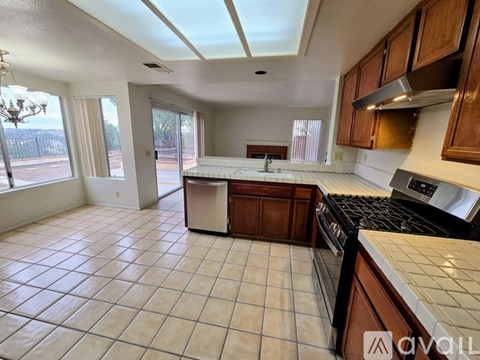 A kitchen with tile flooring and a stove top oven.