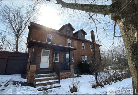 A house with a white door and windows is surrounded by snow.