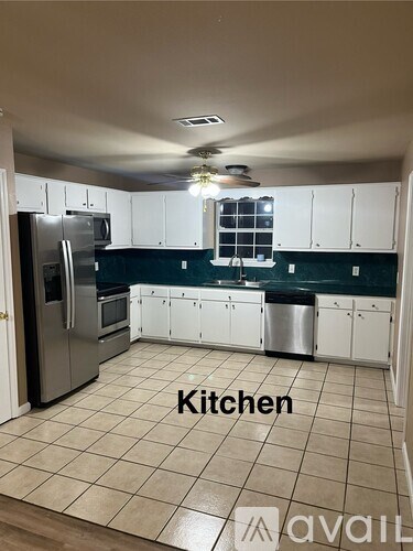 A kitchen with white cabinets and a tile floor.