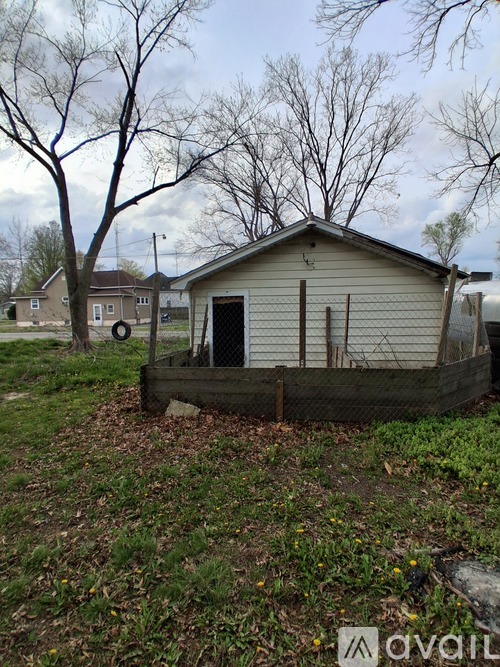 A small house with a fence in front of it.