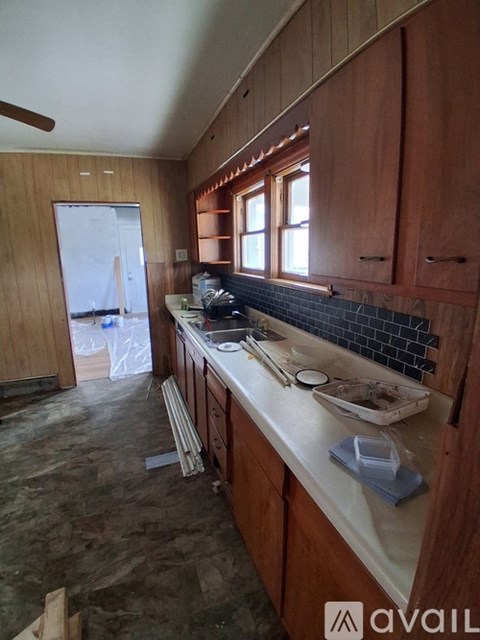 A kitchen under construction with wooden cabinets and a countertop.