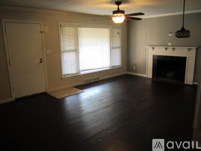 A room with a fireplace and a ceiling fan.