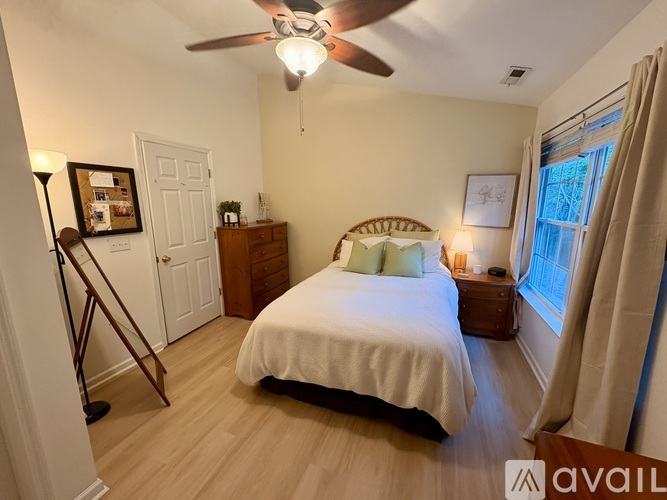 A bedroom with a bed, dresser, and window.