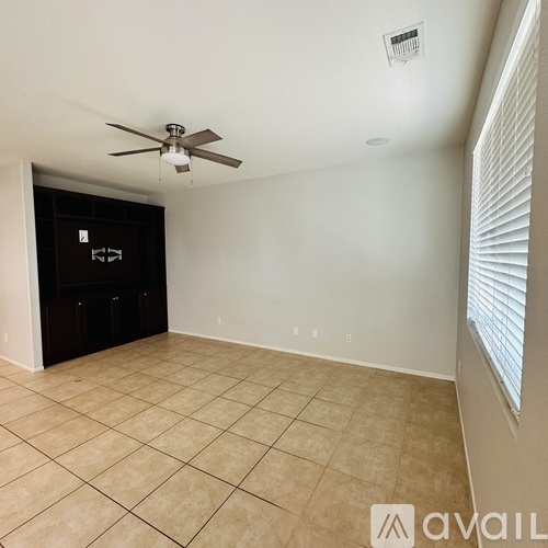 A room with a ceiling fan and tiled floor.