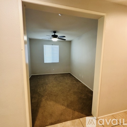 A room with a ceiling fan and carpeted floor.