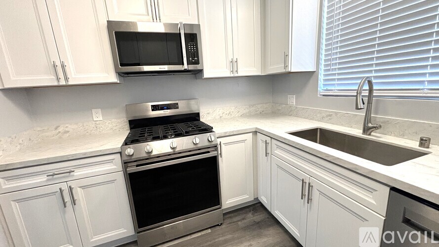 A kitchen with white cabinets and a stainless steel oven.