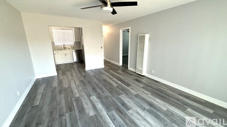 A room with a ceiling fan and a wooden floor.