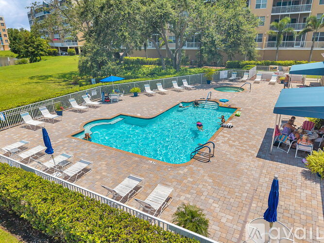A large outdoor pool surrounded by lounge chairs and umbrellas.