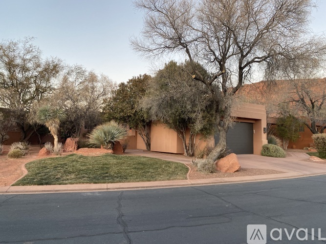 A house with a driveway and trees in the background.