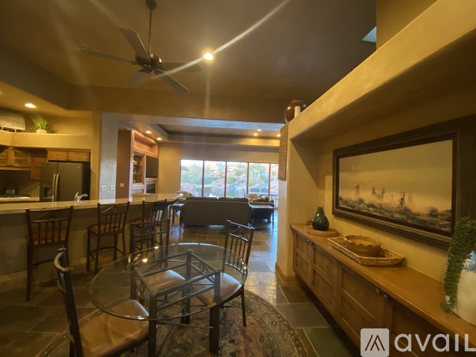 A dining room with a glass table and chairs.