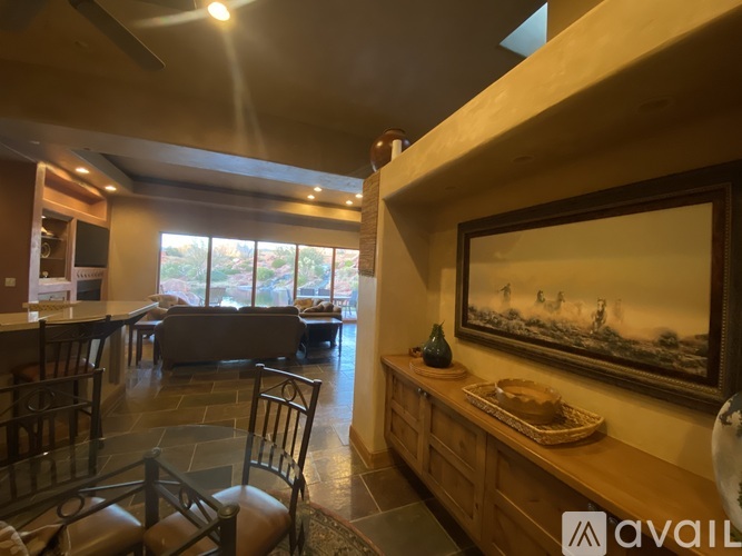 A living room with a large painting on the wall and a wooden bench.