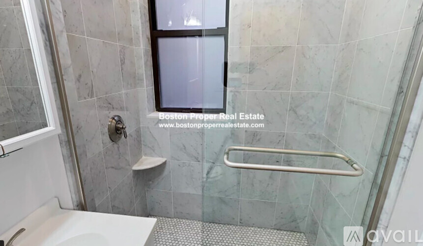 A shower area with a glass door and a window.