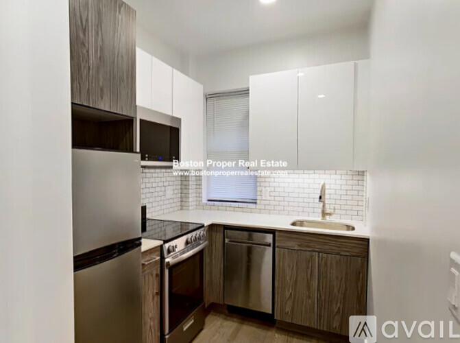 A kitchen with wooden cabinets and stainless steel appliances is available for rent.