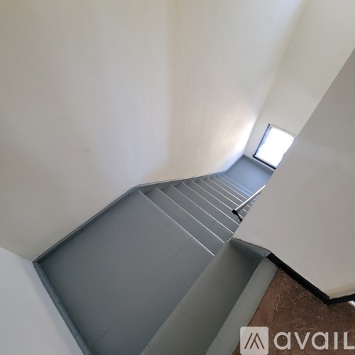 A staircase with a metal railing and wooden steps.