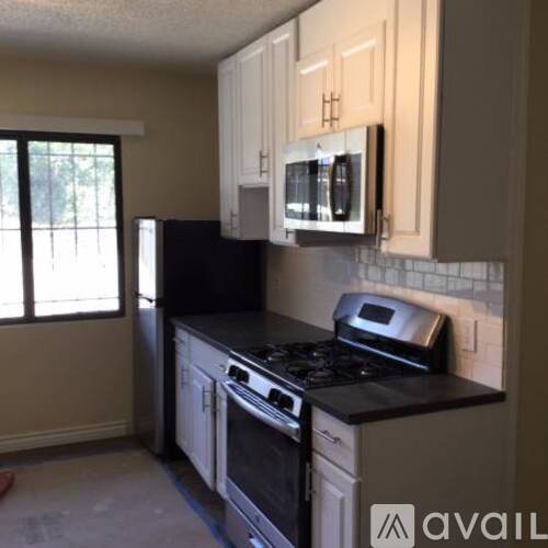 A kitchen with black appliances and white cabinets.