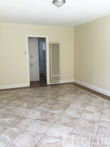 A room with a tiled floor and a door leading to a hallway.