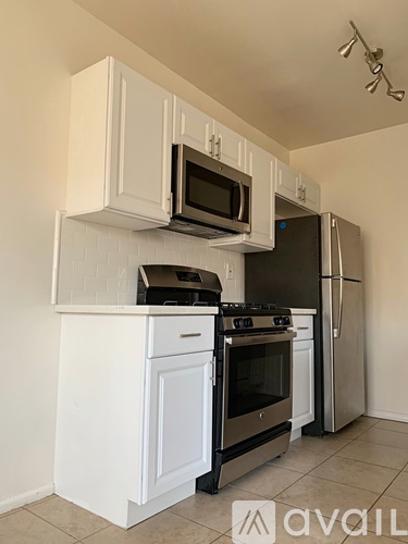 A kitchen with white cabinets and appliances.
