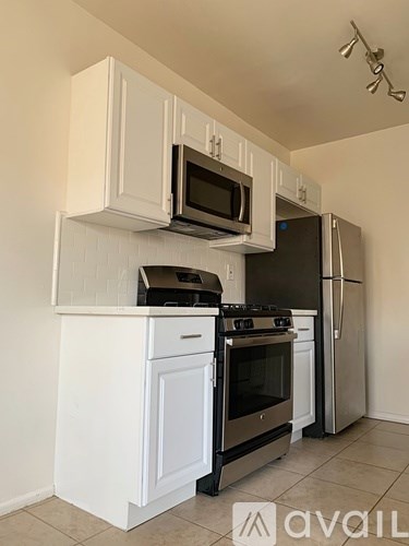 A kitchen with white cabinets and appliances.