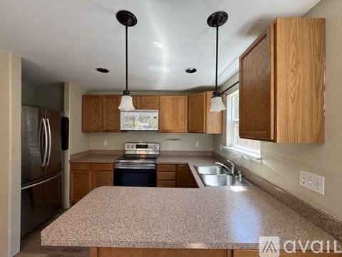 A kitchen with wooden cabinets and granite countertops.