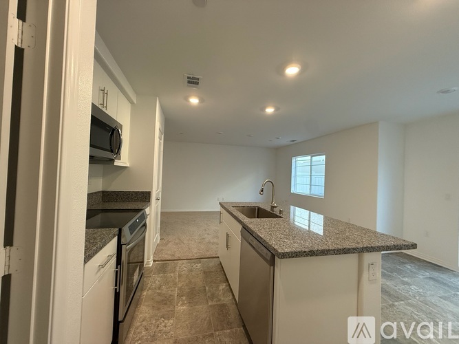 A kitchen with a granite countertop and a window.