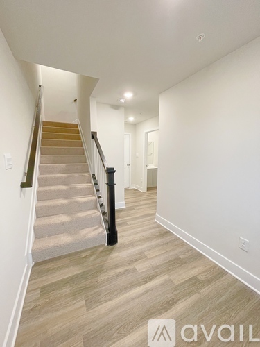 A hallway with a staircase leading to the second floor.